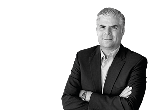 CEO Stefan Kratochwill lächelnd mit verschränkten Armen