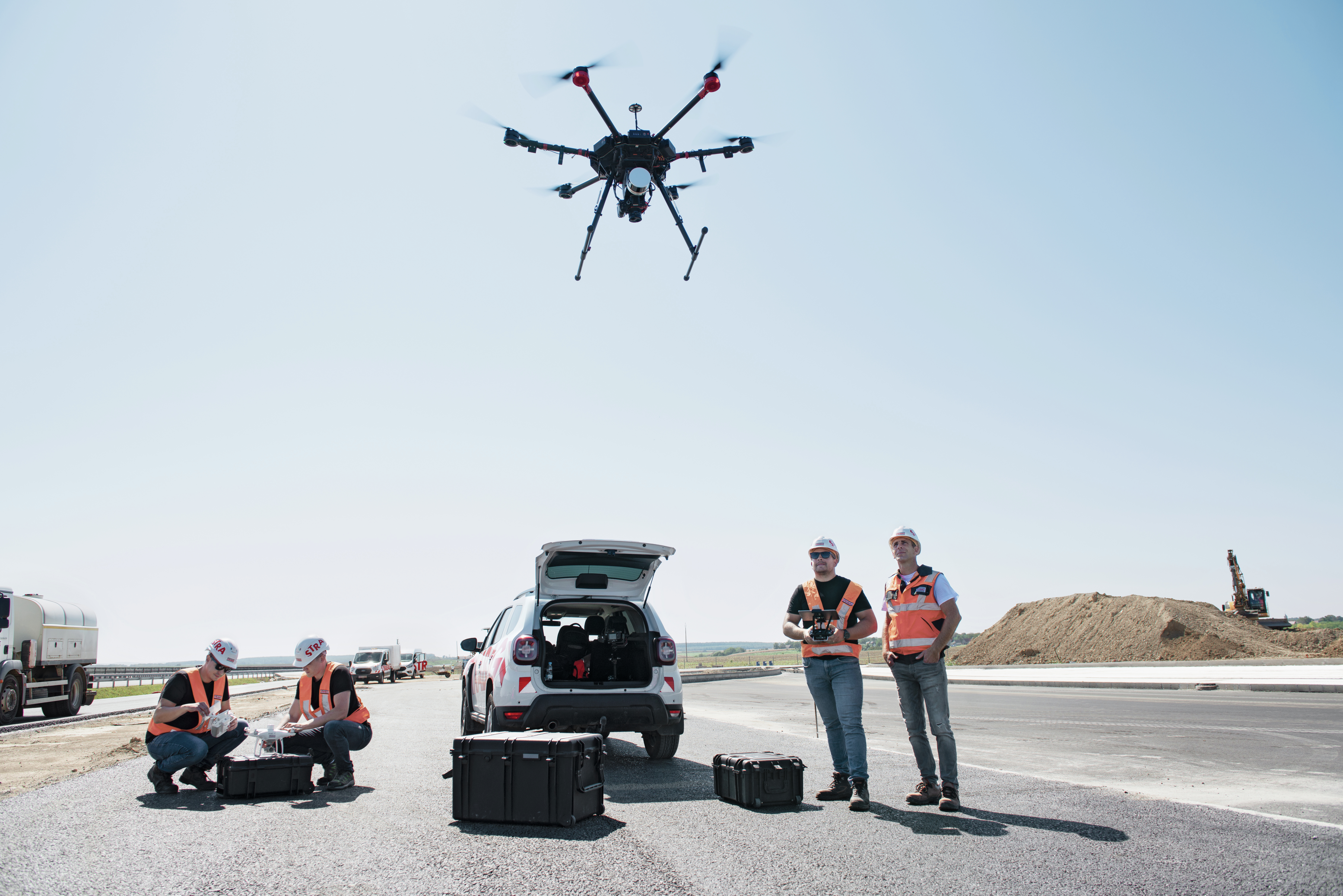 Shot of a team of construction workers operating a drone