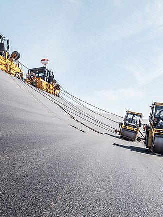Foto von Walzmaschinen die über eine asphaltierte Straße fahren