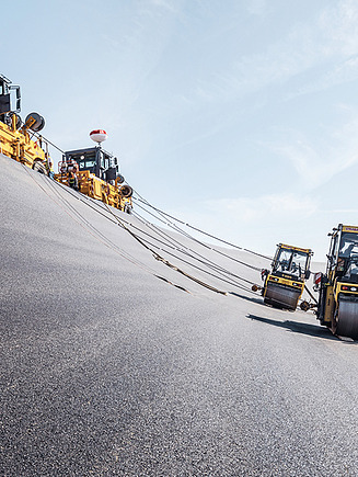 Photo of rolling machines driving over an asphalt road