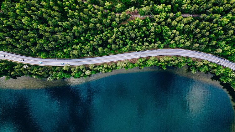 Aerial view of a road running parallel to a lake