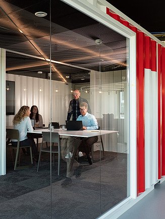 Foto einer Gruppe die in einem STRABAG Container-Büro ein Meeting abhalten